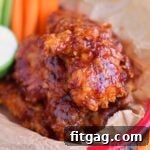 chicken strips with honey barbecue sauce in red plastic basket with carrots and celery sticks.