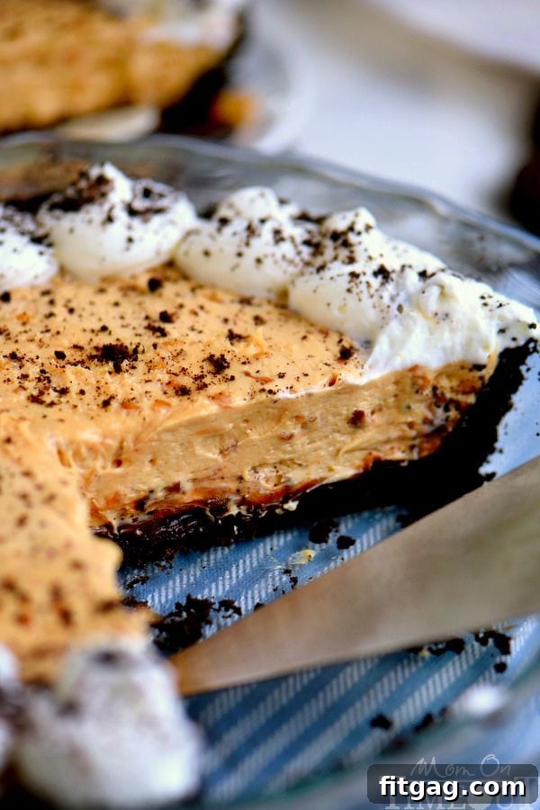 The smooth and creamy peanut butter cheesecake filling being spread evenly over the OREO crust.