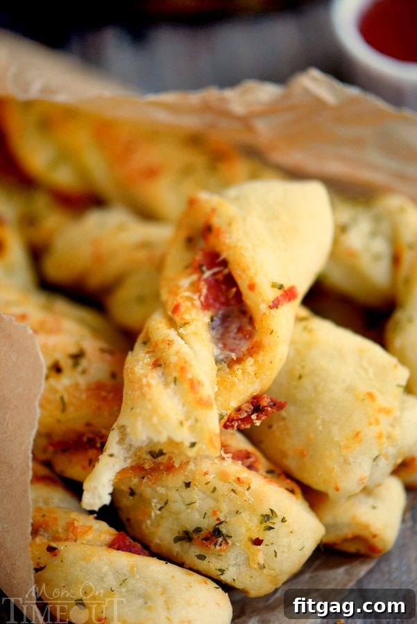 Savory Pepperoni Pizza Spirals 7 A platter of golden-brown Pepperoni Pizza Twists, ready to be enjoyed, with dipping sauces in the background