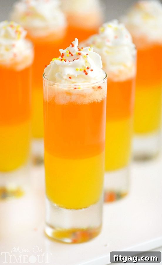 A perfect Candy Corn Popper topped with a swirl of Reddi-wip and colorful sprinkles, ready to be enjoyed.