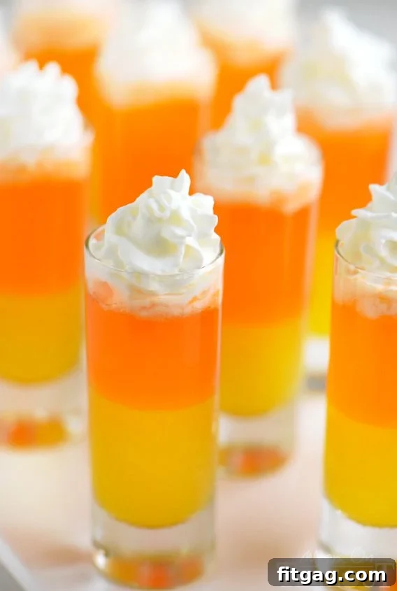 Rows of Candy Corn Poppers showing their beautiful layers, lined up before adding the whipped topping.