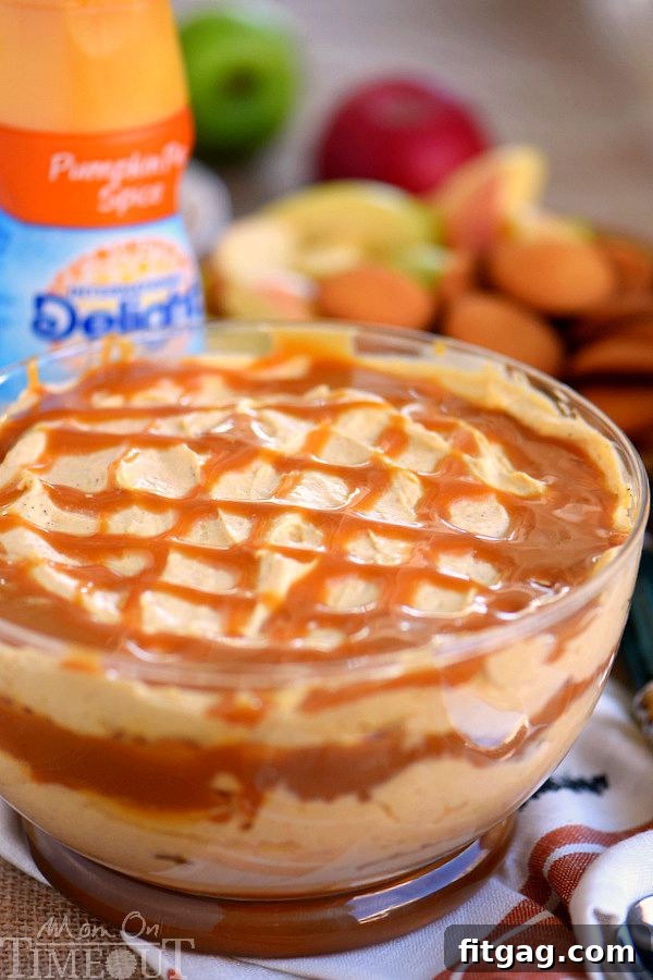 A close-up shot of the rich Caramel Pumpkin Cheesecake Dip, showcasing the smooth texture and a generous caramel swirl, ready to be served with dippers.