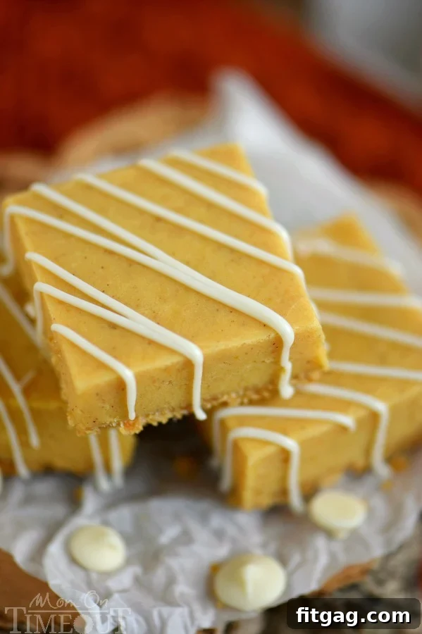 Close-up of a stack of pumpkin fudge squares, each topped with a delicate white chocolate drizzle, ready to be enjoyed.