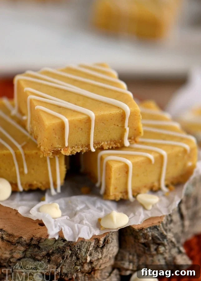 A close-up of a hand gently pressing down on the graham cracker crust in a baking pan, preparing it for the pumpkin fudge.