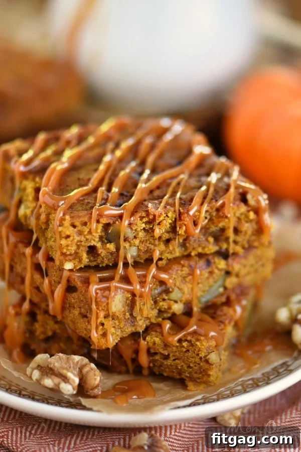 A close-up of a tray of freshly baked Caramel Pumpkin Blondies, showing their golden-brown edges and chewy interior.