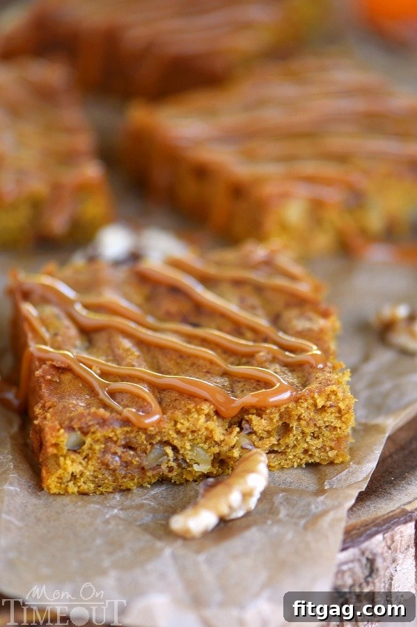 A beautifully composed shot of Caramel Pumpkin Blondies, with a rich caramel sauce drizzled over each square.