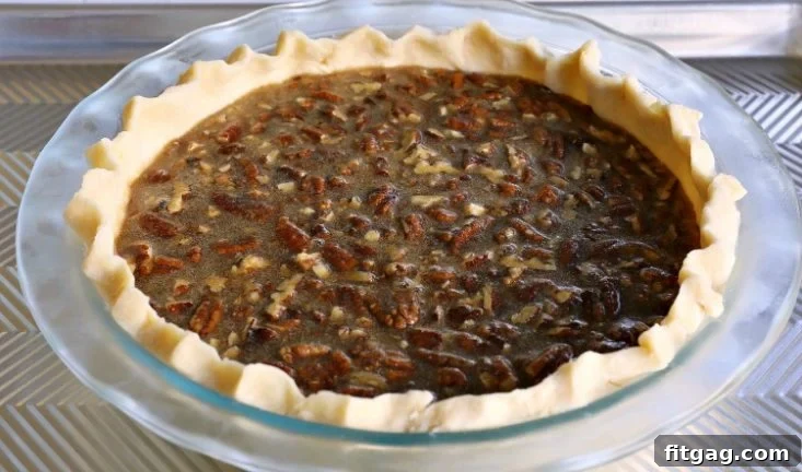 Decadent Brown Sugar Pecan Pie 7 A baked pecan pie on a baking sheet, showcasing the beautiful golden crust and rich pecan topping.