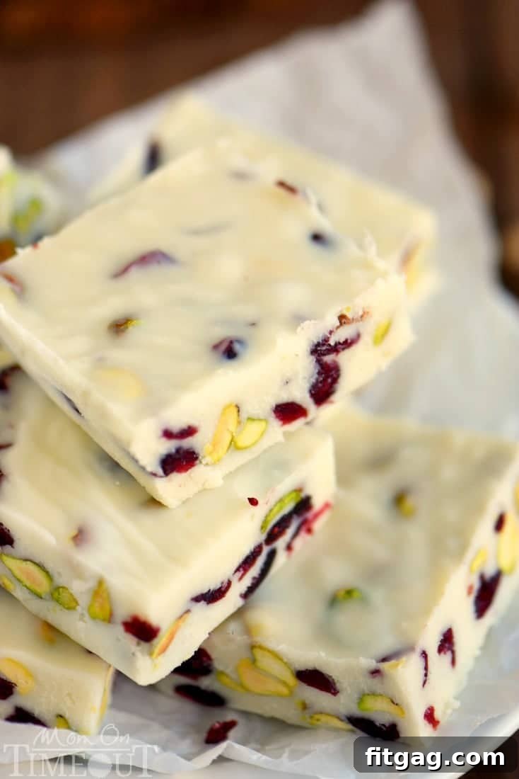 Easy Cranberry Pistachio Fudge squares on a rustic wooden board