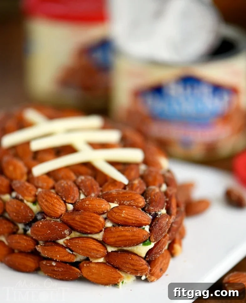 Close-up of the Cranberry Almond Cheese Ball shaped like a football, artfully decorated with cheese strips to resemble laces.