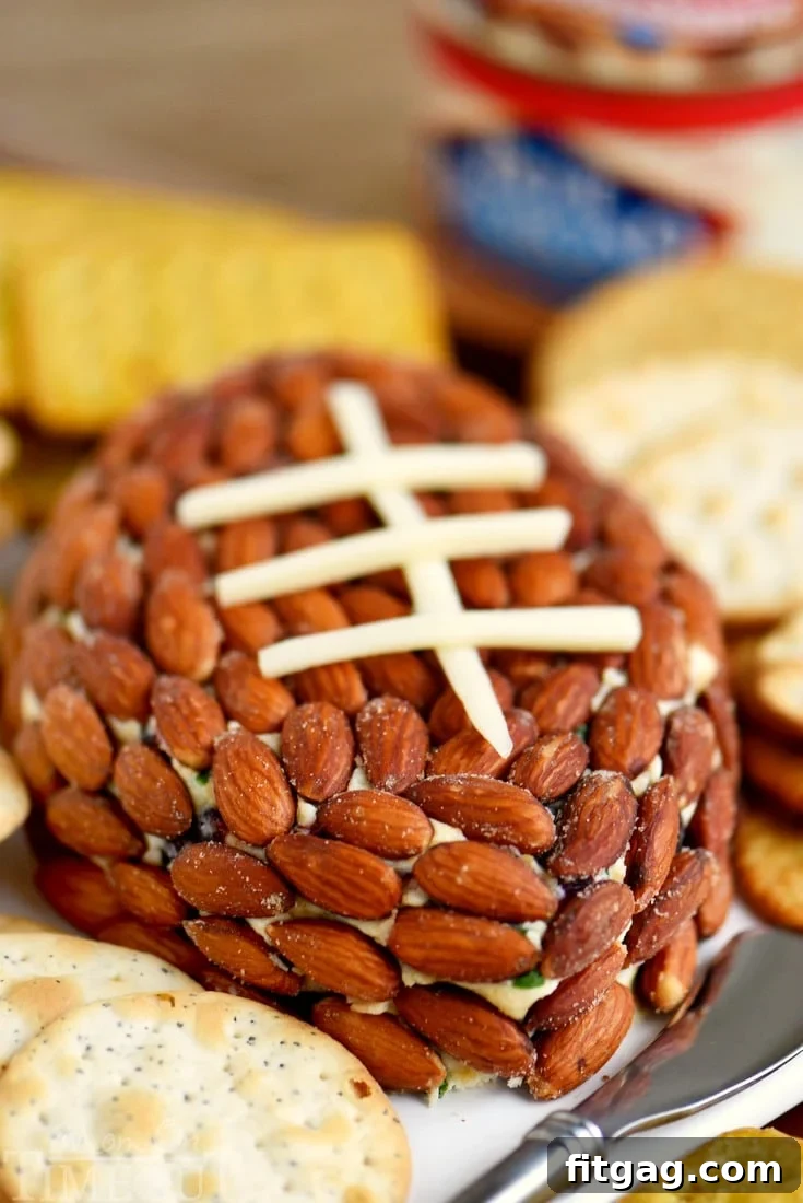The Cranberry Almond Cheese Ball served with an assortment of crackers and a festive sprig, perfect for holiday gatherings.