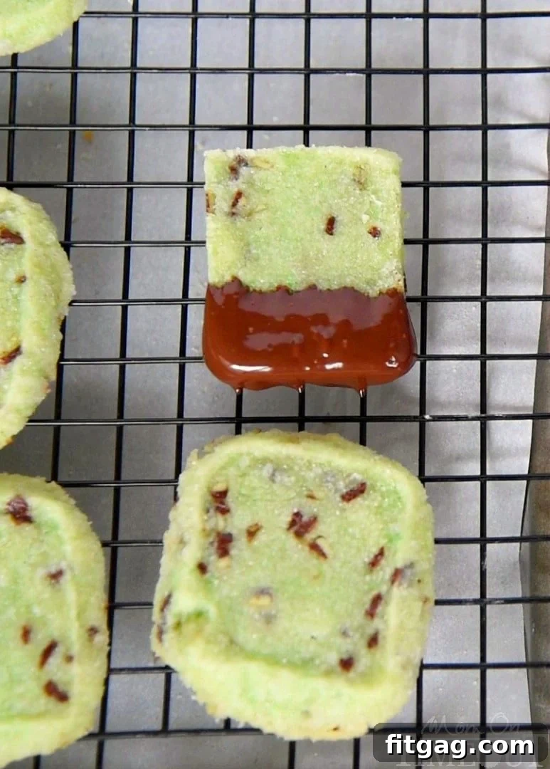 Close-up of freshly baked Chocolate Dipped Mint Shortbread Cookies, showcasing the smooth, dark chocolate coating and the subtle green hue of the mint shortbread.