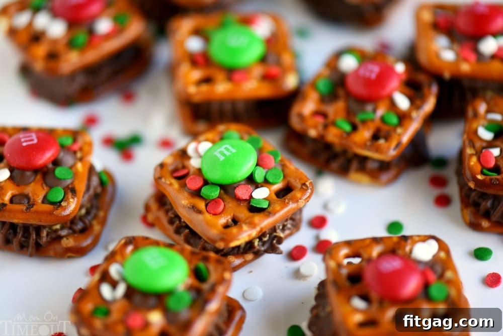Close-up of freshly baked Reese's Holiday Pretzel Bites with melted chocolate and M&Ms, ready to be cooled and enjoyed.