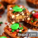 A single Reese's Holiday Pretzel Bite on a small white plate, showing the layers of pretzel, Reese's, and M&M with sprinkles.