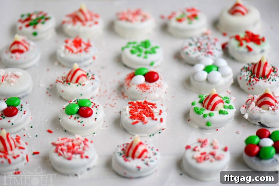 Batch of freshly decorated Holiday Dipped Oreos cooling on a baking sheet with parchment paper.