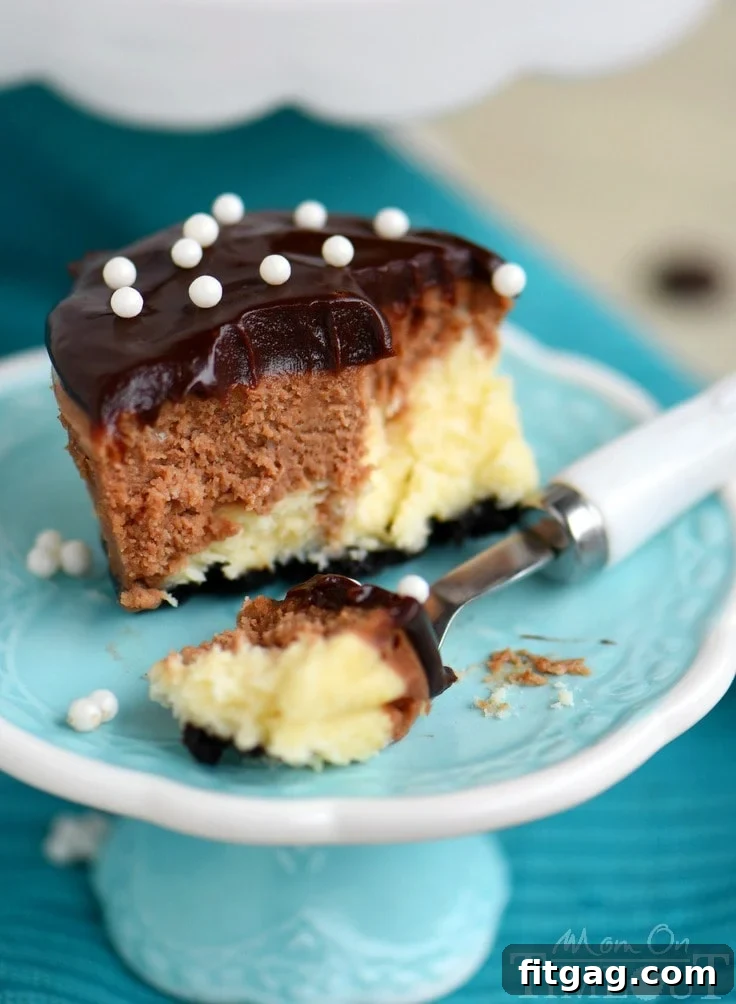 Close-up of a mini cheesecake topped with shimmering chocolate ganache and delicate sugar pearls, ready for a celebration.