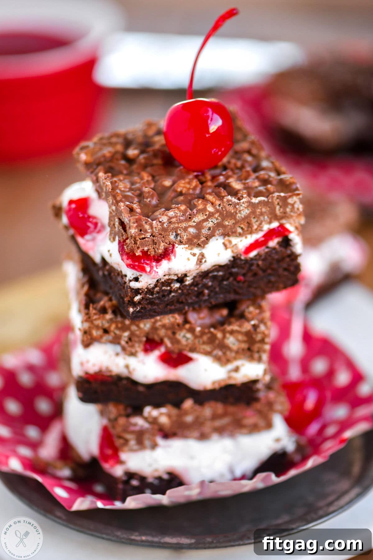 Cherry Brownie Bliss Bars 2 Stack of three cherry brownie dream bars on a metal plate with a maraschino cherry on top, showcasing the decadent layers.