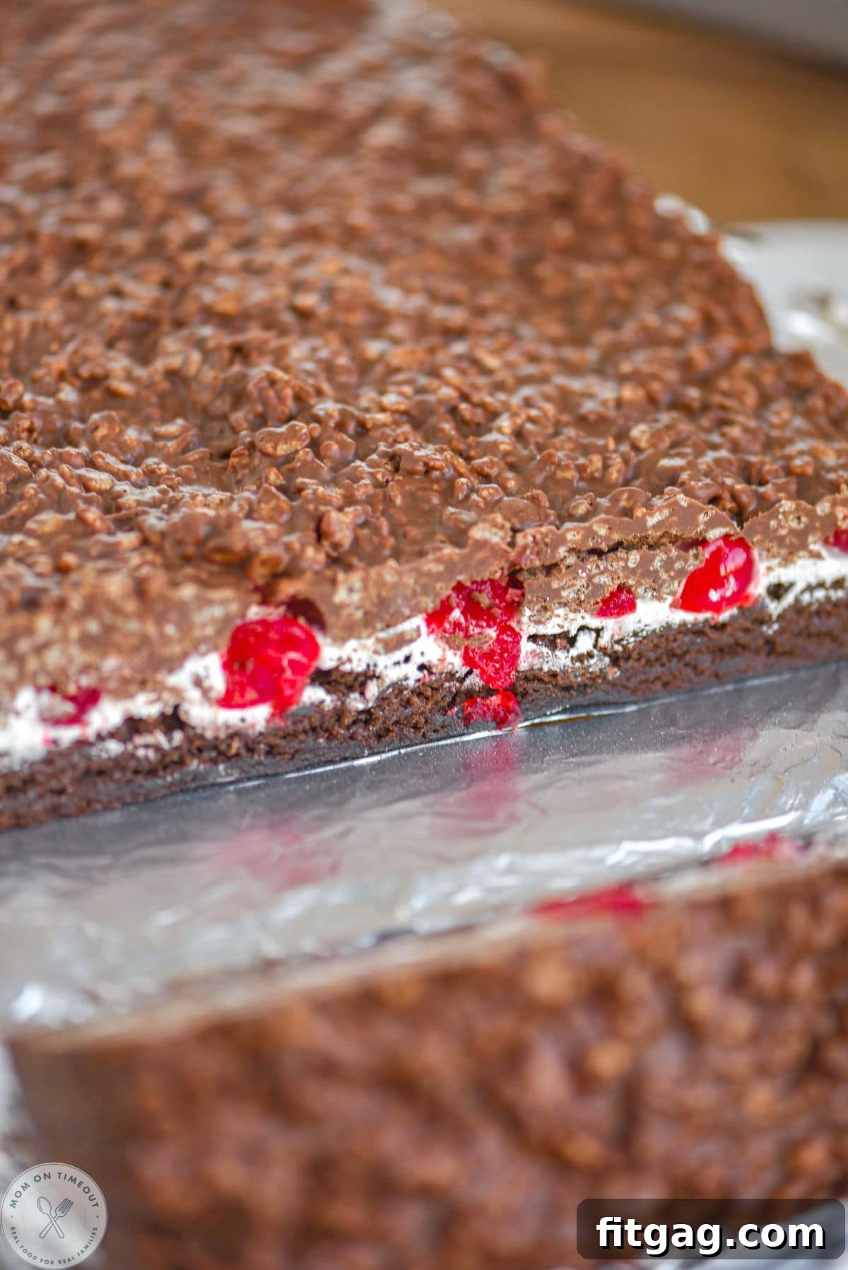 Cherry Brownie Bliss Bars 4 Cherry dream bars cut open on foil so you can see each distinct layer, from brownie to marshmallow to cherries and the chocolate peanut butter crunch.