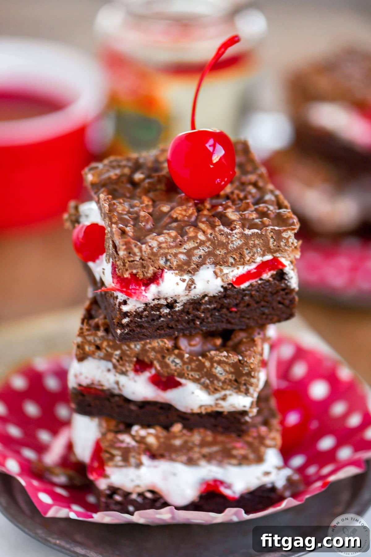 Cherry Brownie Bliss Bars 5 Stack of three cherry brownie dream bars on a metal plate with a maraschino cherry on top, highlighting the different layers.