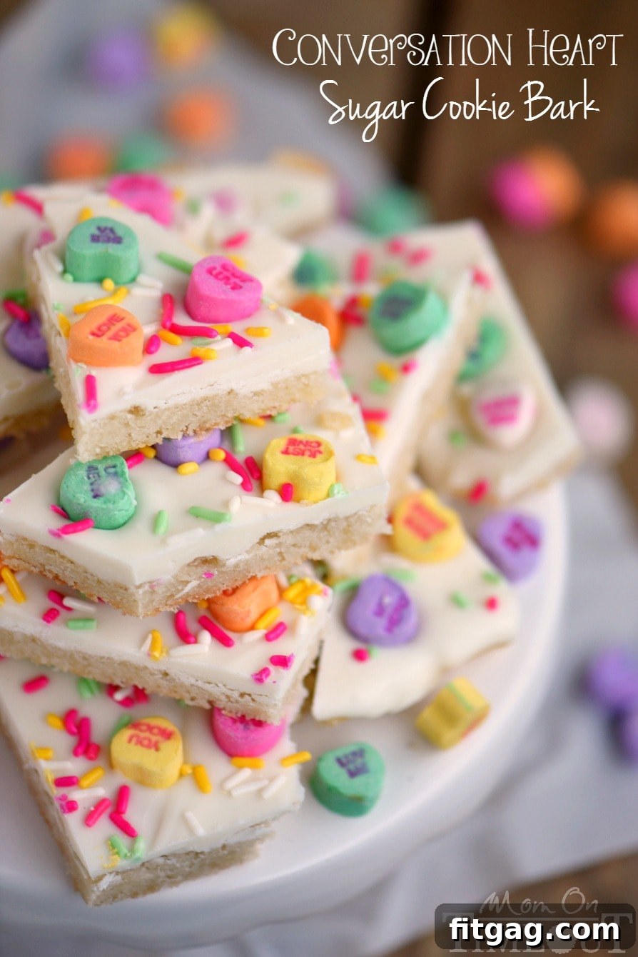 Sweet Talk Sugar Cookie Bark 2 Festive Conversation Heart Sugar Cookie Bark adorned with sprinkles and candies, ready for Valentine's Day celebrations.
