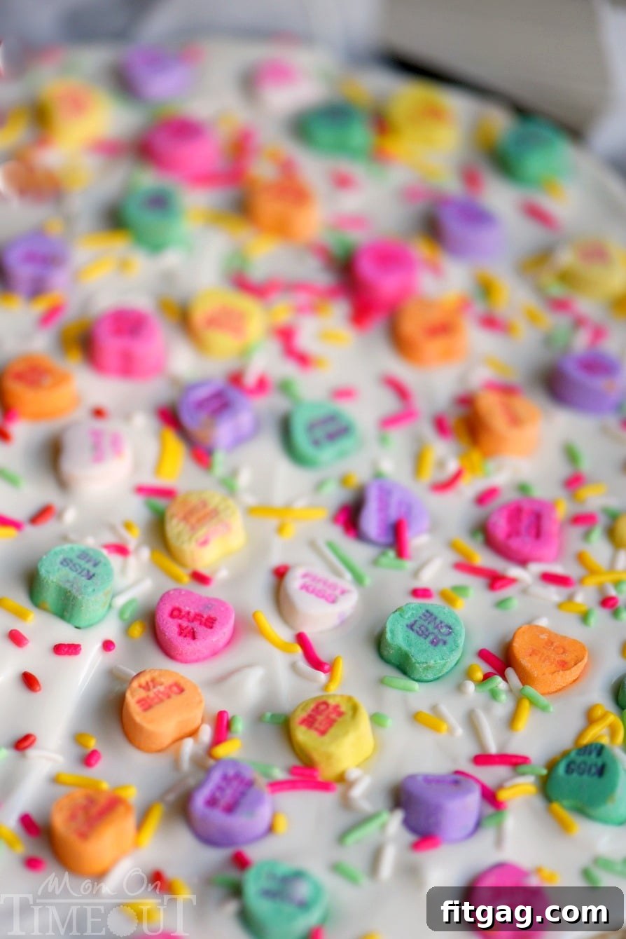 Sweet Talk Sugar Cookie Bark 3 Close-up of Conversation Heart Sugar Cookie Bark, showcasing the colorful candy hearts and sprinkles on a vanilla base.