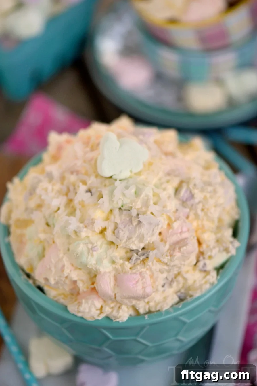 An overhead view of a large green serving bowl filled with creamy, pastel-colored Easter Fluff, showcasing its inviting texture and festive appearance.