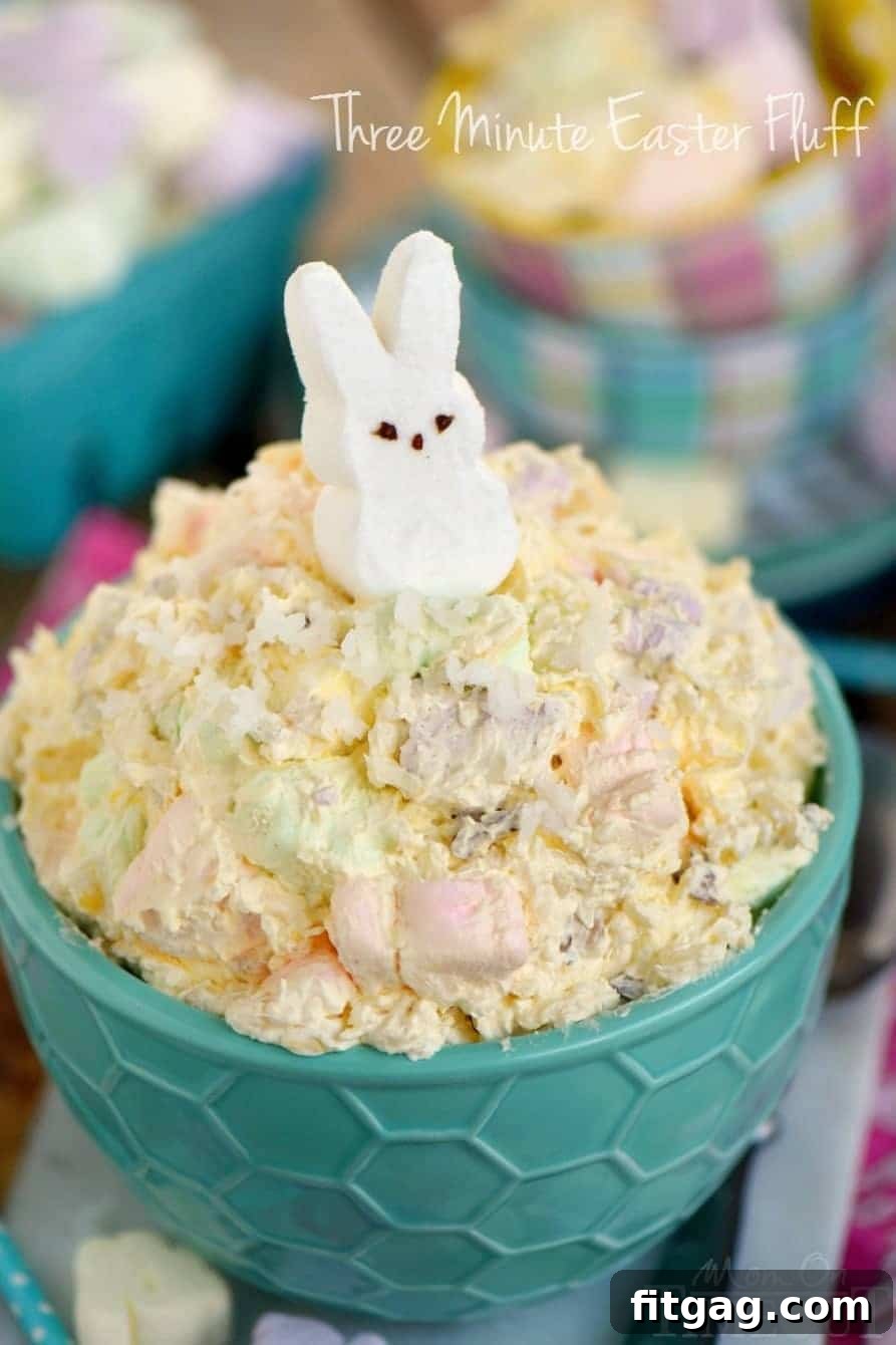 A bowl of delightful Easter dessert fluff, adorned with a white marshmallow peep, highlighting its light texture and festive charm.