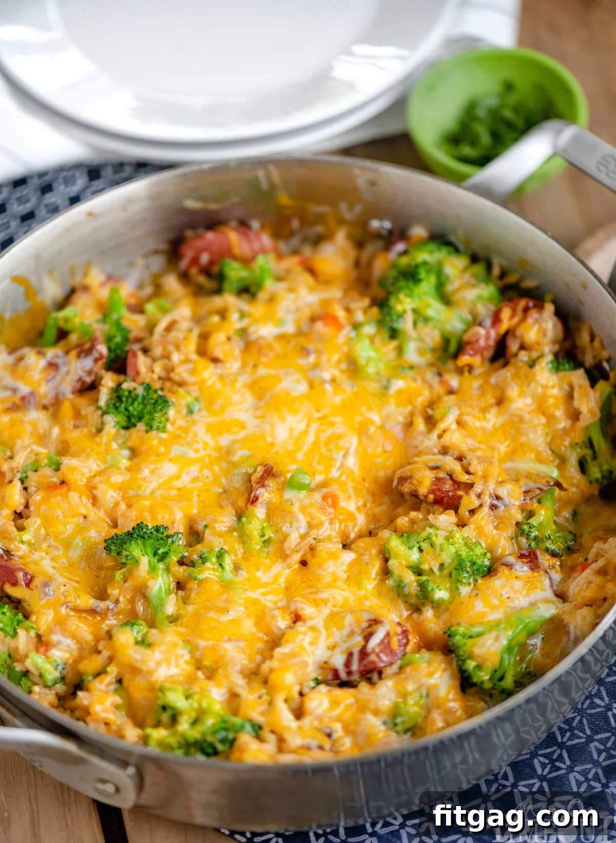One-Skillet Cheesy Kielbasa and Broccoli Rice 6 Angled look down at a skillet dinner topped with melted cheese ready to be served and enjoyed. Broccoli, rice and kielbasa can be seen under the cheese.
