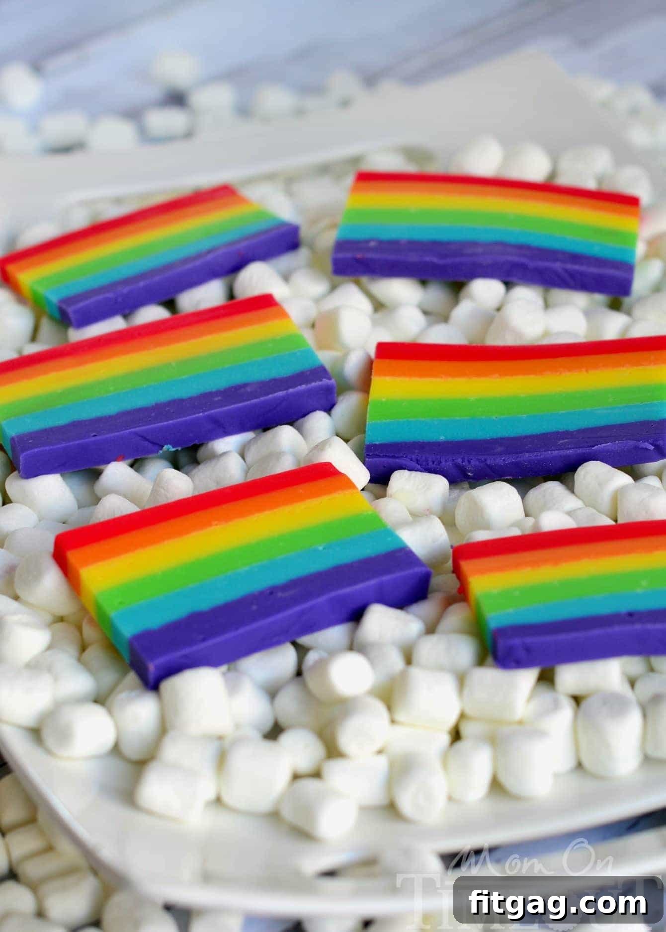 Stack of colorful rainbow fudge slices, highlighting the individual flavor layers.