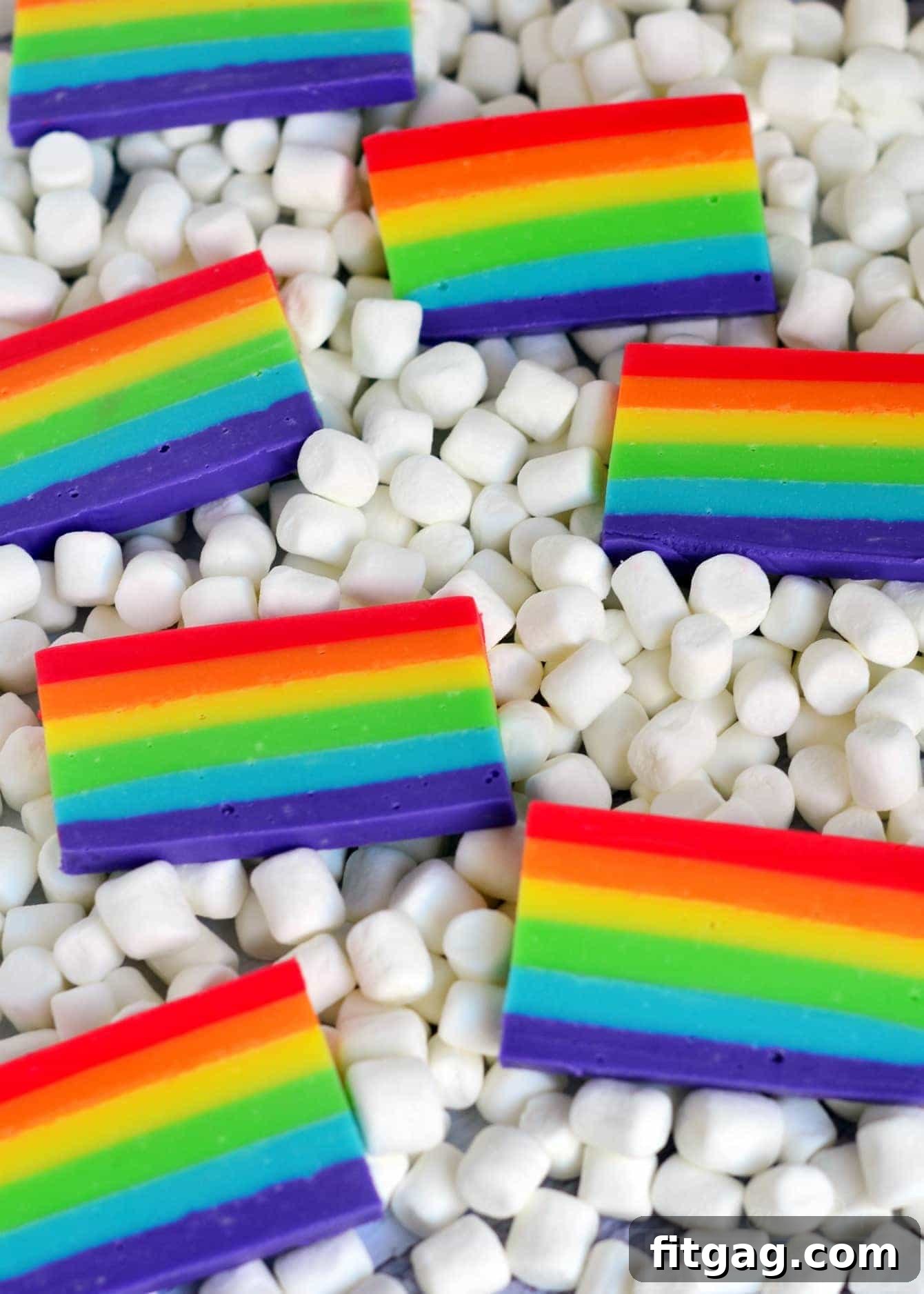 Overhead shot of rainbow fudge pieces arranged artfully, with marshmallows scattered around.