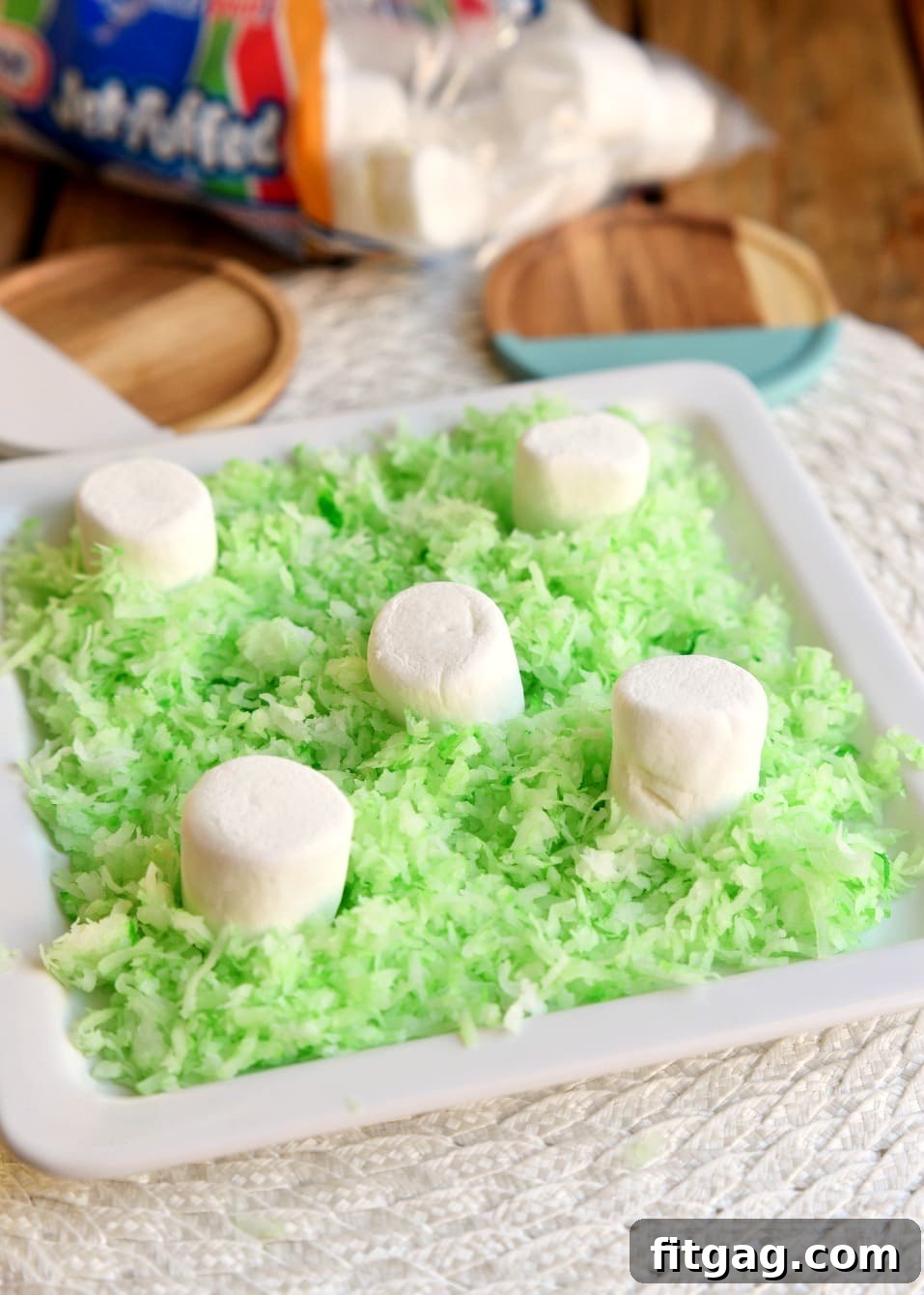 Reese's Easter Bunny Treats 5 Arranging green coconut grass and large marshmallows as stands for the Reese's Easter Bunnies.