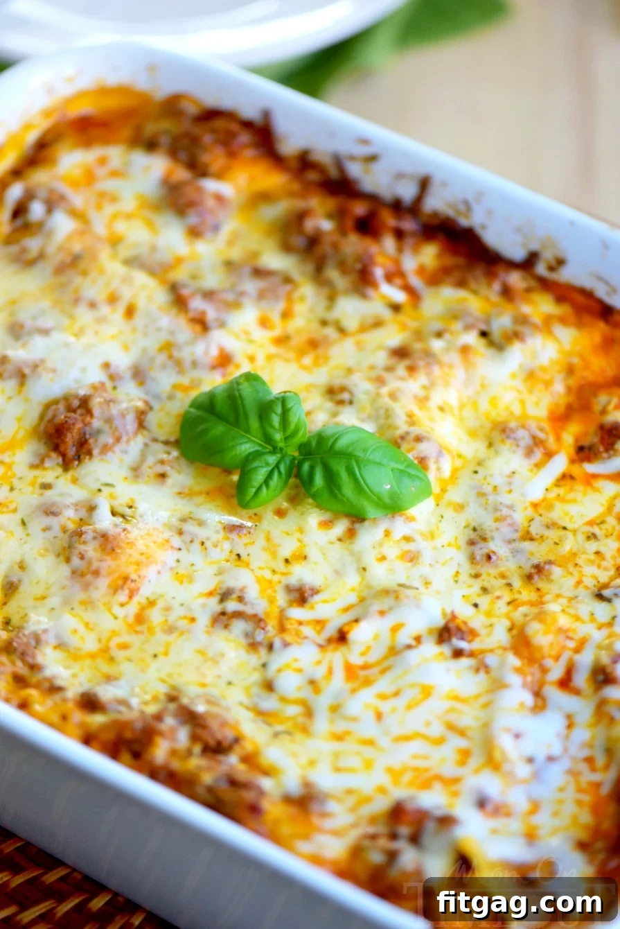 Baked easy lazy day lasagna in a white casserole dish, showing layers of pasta, meat, and cheese, ready to be served.