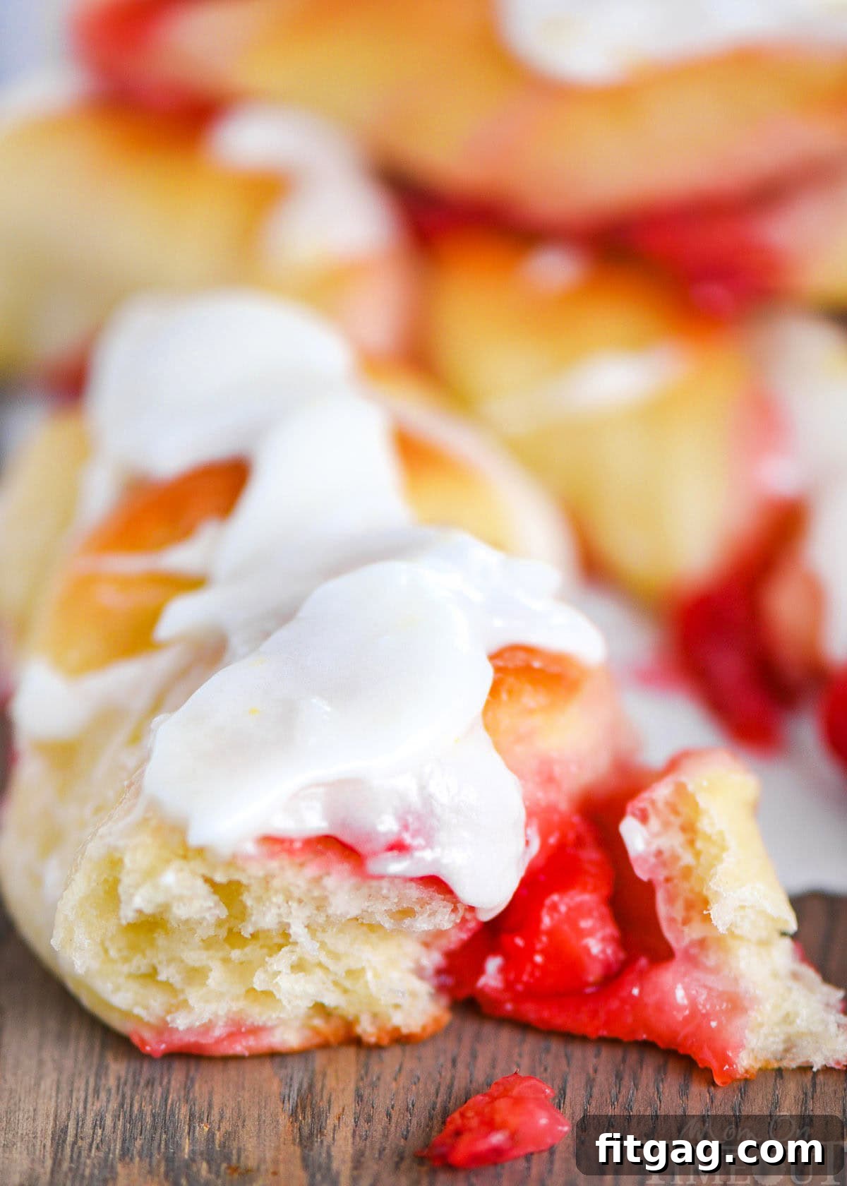 A close-up shot of a single Strawberry Twist, showcasing its soft, twisted dough and a peek of the sweet strawberry filling.