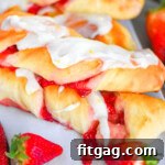 A side shot of Strawberry Twists with strawberries in front of them.