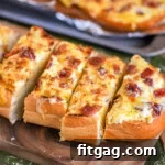 Wide shot of a half loaf of cheese bread cut into slices and ready to serve.