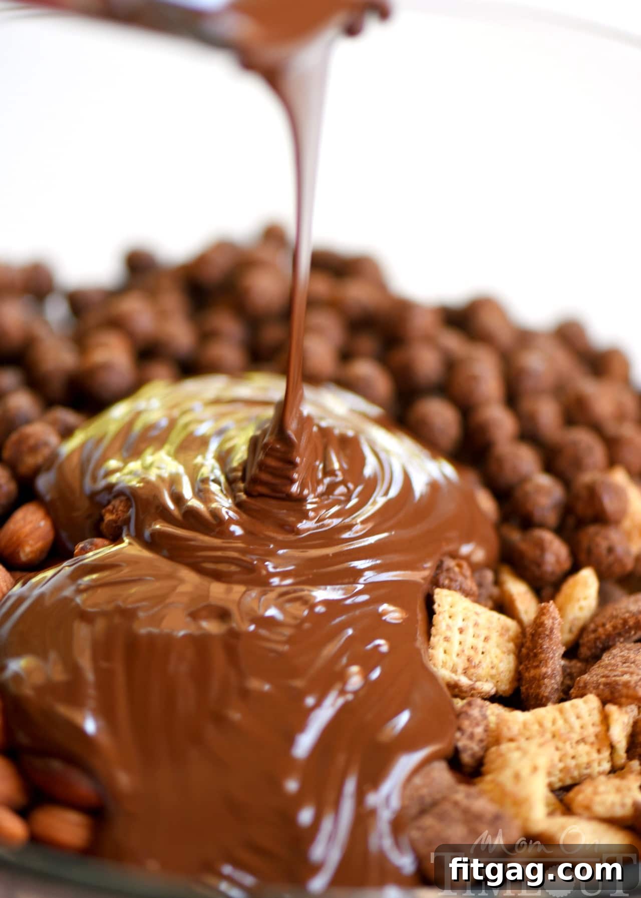Melted chocolate and peanut butter mixture in a glass bowl, ready to coat the cereal.