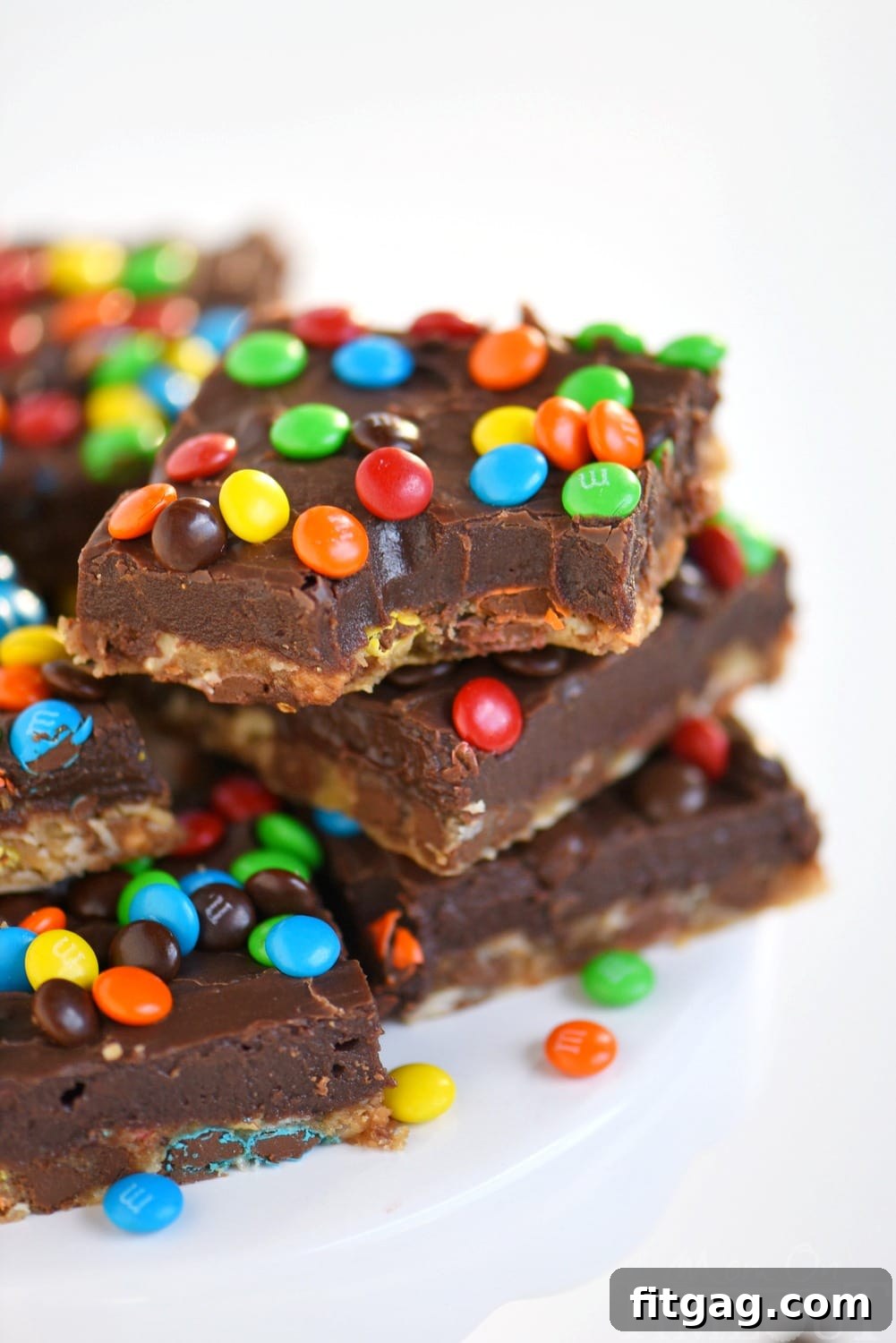 Monster Fudge Bars with a thick oatmeal chocolate chip cookie layer and a smooth fudge topping studded with M&M's.