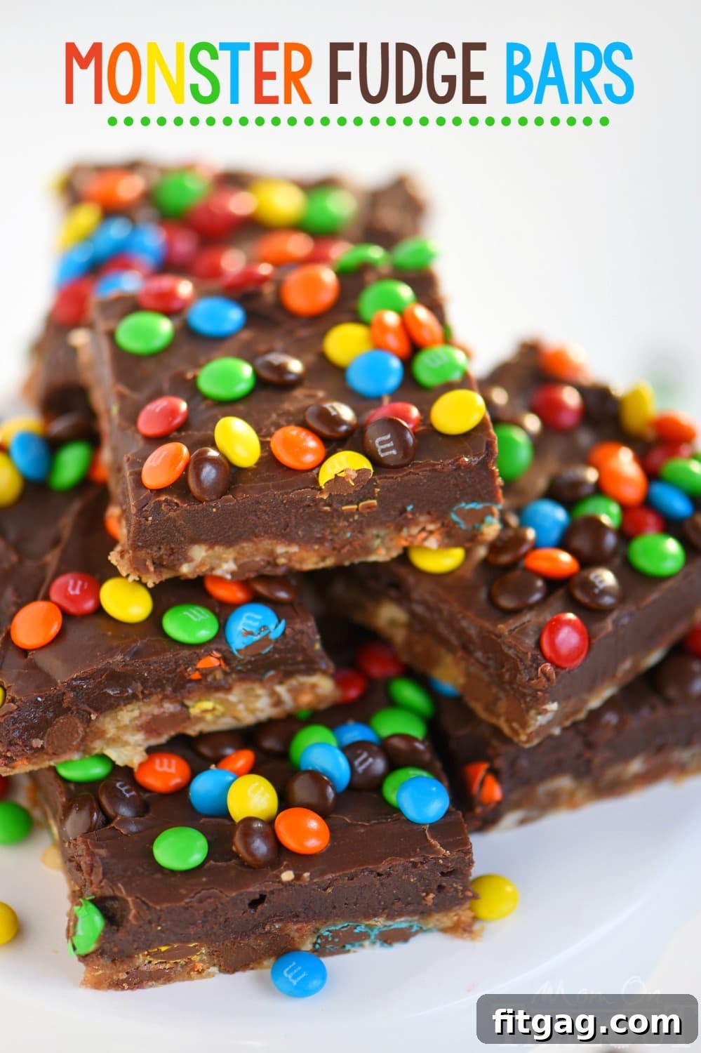 A close-up of a delicious Monster Fudge Bar, showcasing its intricate layers of oatmeal cookie and smooth chocolate fudge, adorned with mini M&M's, ready for a bite.