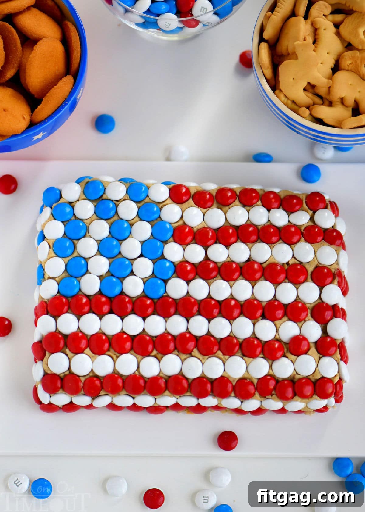 Party-Perfect Chocolate Chip Cookie Dough Dip 2 Overhead shot of chocolate chip cookie dip on white board decorated to look like the US flag with MMs.