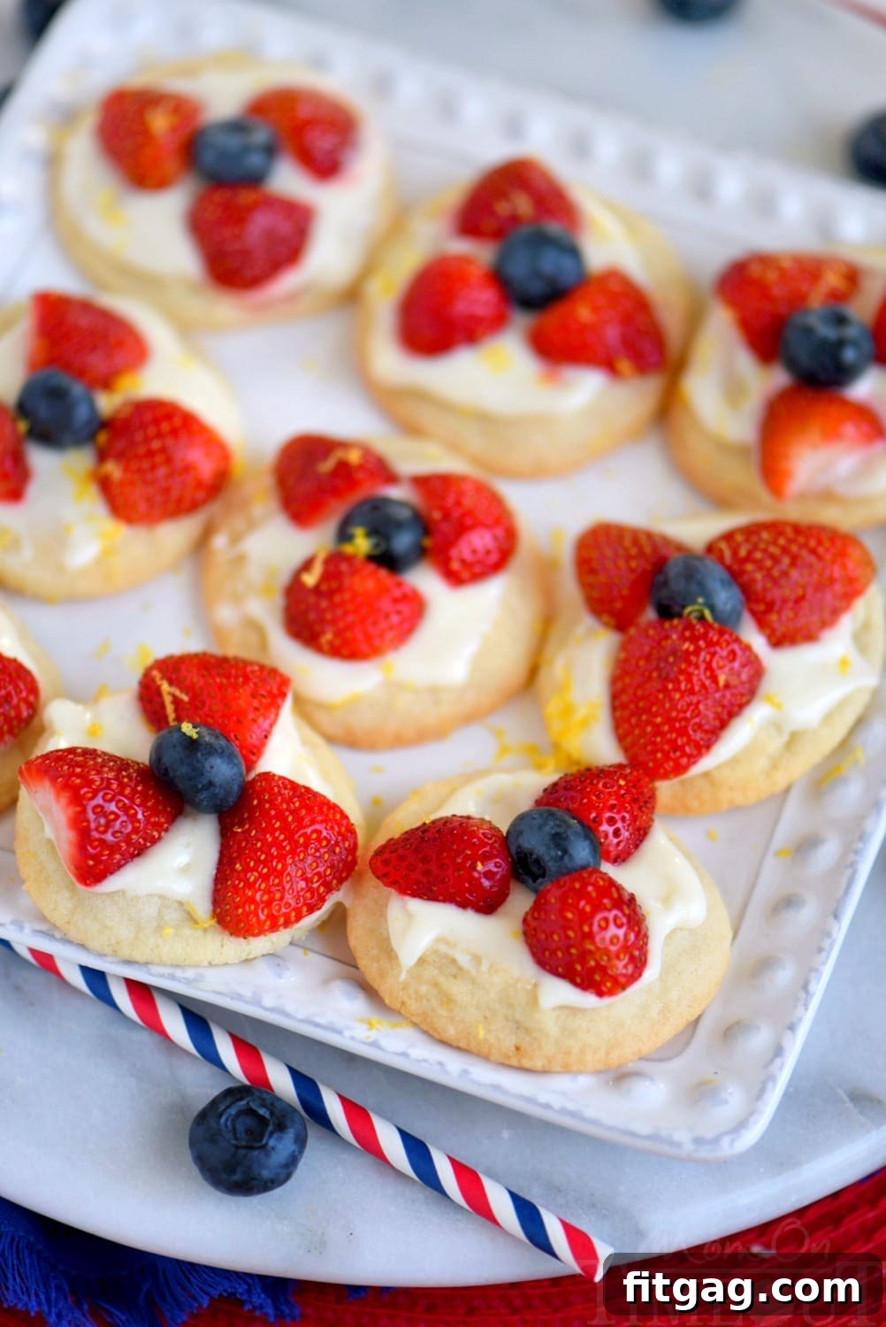 Close-up of a Berries 'N Cream Cookie with a generous swirl of lemon cream cheese frosting and colorful fresh berries.
