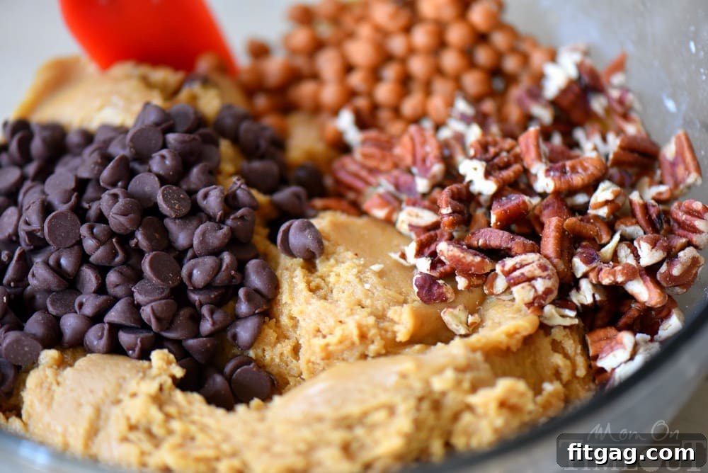 Outrageous Chocolate Chip Turtle Pudding Cookies are loaded with chocolate chips, pecans, and caramel. These giant, bakery style cookies will steal the show! Extra chewy and packed with flavor! A close-up of a freshly baked cookie with melted chocolate and caramel.