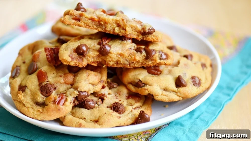 chocolate-chip-turtle-cookies-wide - A wide shot of several freshly baked chocolate chip turtle cookies cooling on a rack.