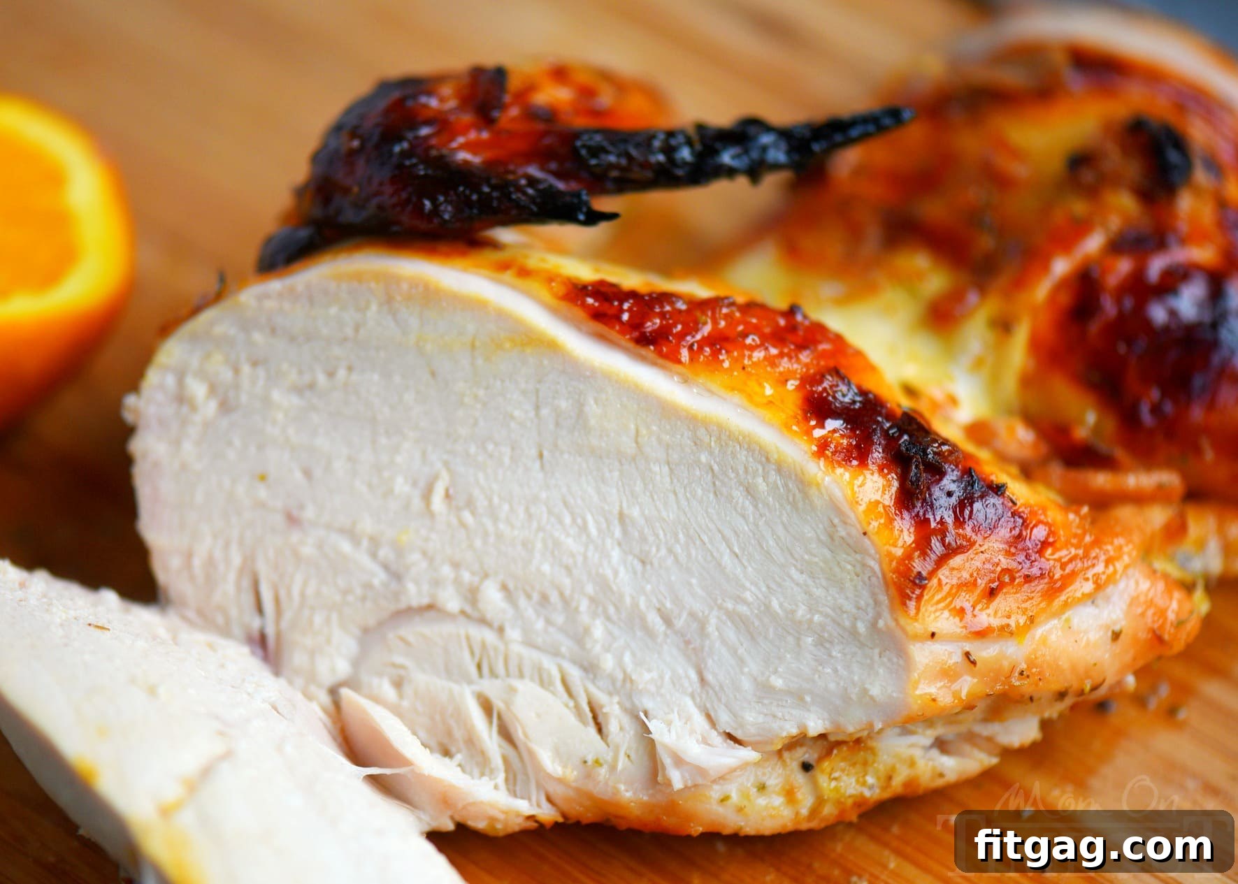 Close-up of a golden-brown Citrus Glazed Roast Chicken, showcasing its crispy skin and succulent texture, garnished with fresh citrus slices.