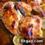 top down look at half a chicken roasted with a lemon and orange glaze sitting on a sheet pan.