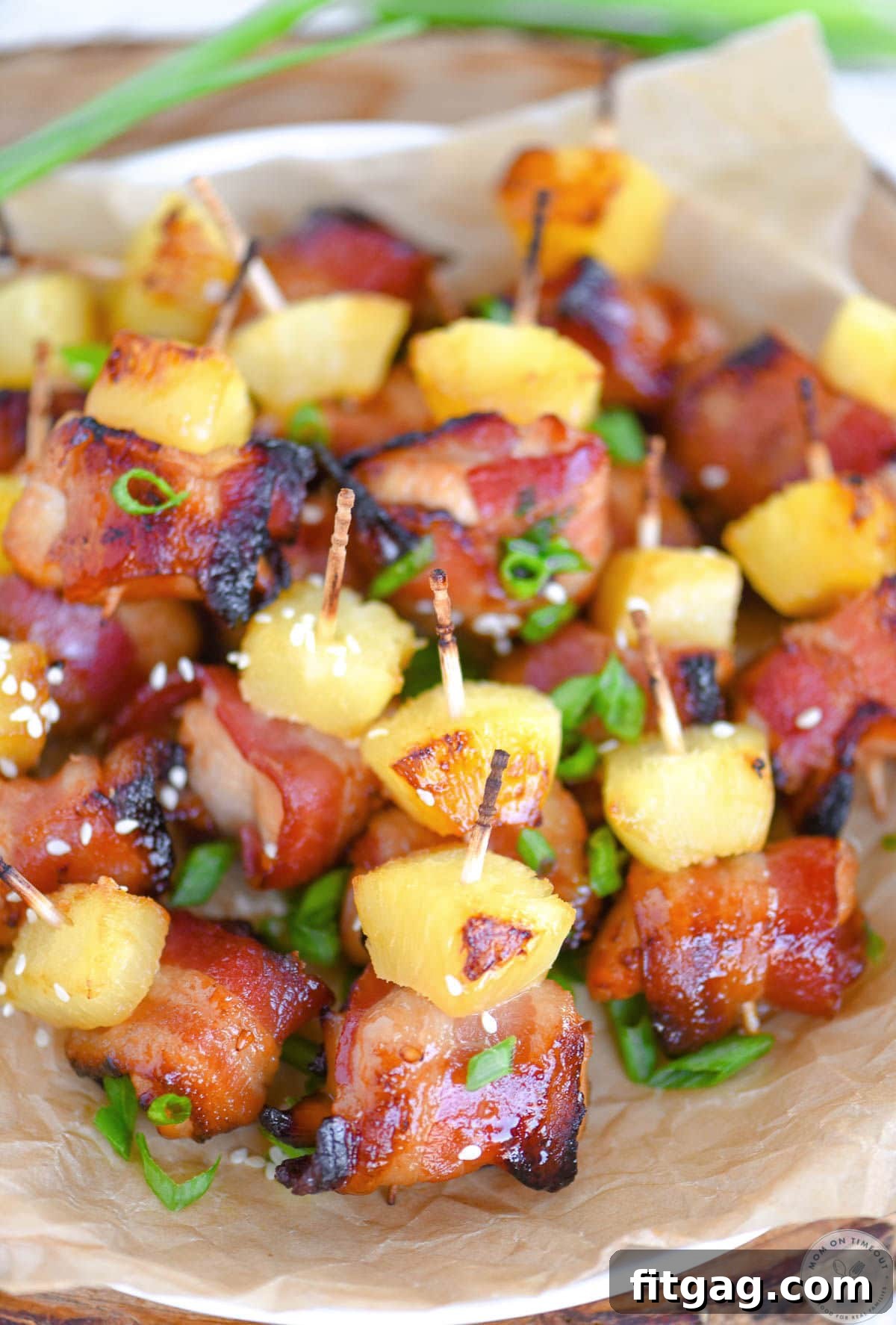Overhead shot of bacon chicken teriyaki bites on white round plate lined with parchment.