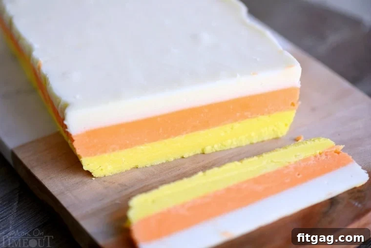 No-Bake Candy Corn Fudge Bliss 2 Close-up of vibrant orange and yellow candy corn fudge layers, showing the smooth, creamy texture.
