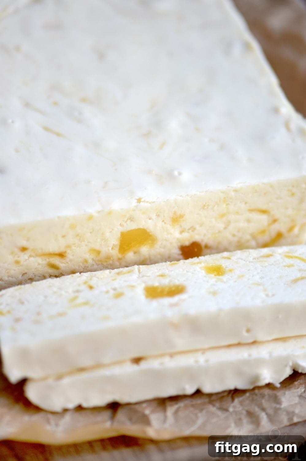 Tropical Pineapple Fudge Bliss 4 A beautifully textured slice of Perfect Pineapple Fudge, showcasing the creamy base infused with golden pineapple bits, hinting at its exquisite flavor and smooth, decadent consistency. A delightful homemade treat. // Mom On Timeout