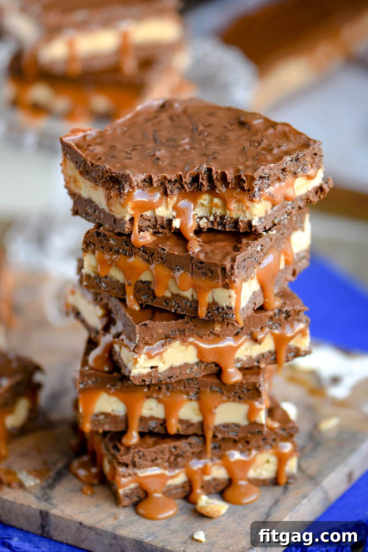 stack of bars with nougat, caramel and crispy chocolate layers. Top bar has a bite taken.