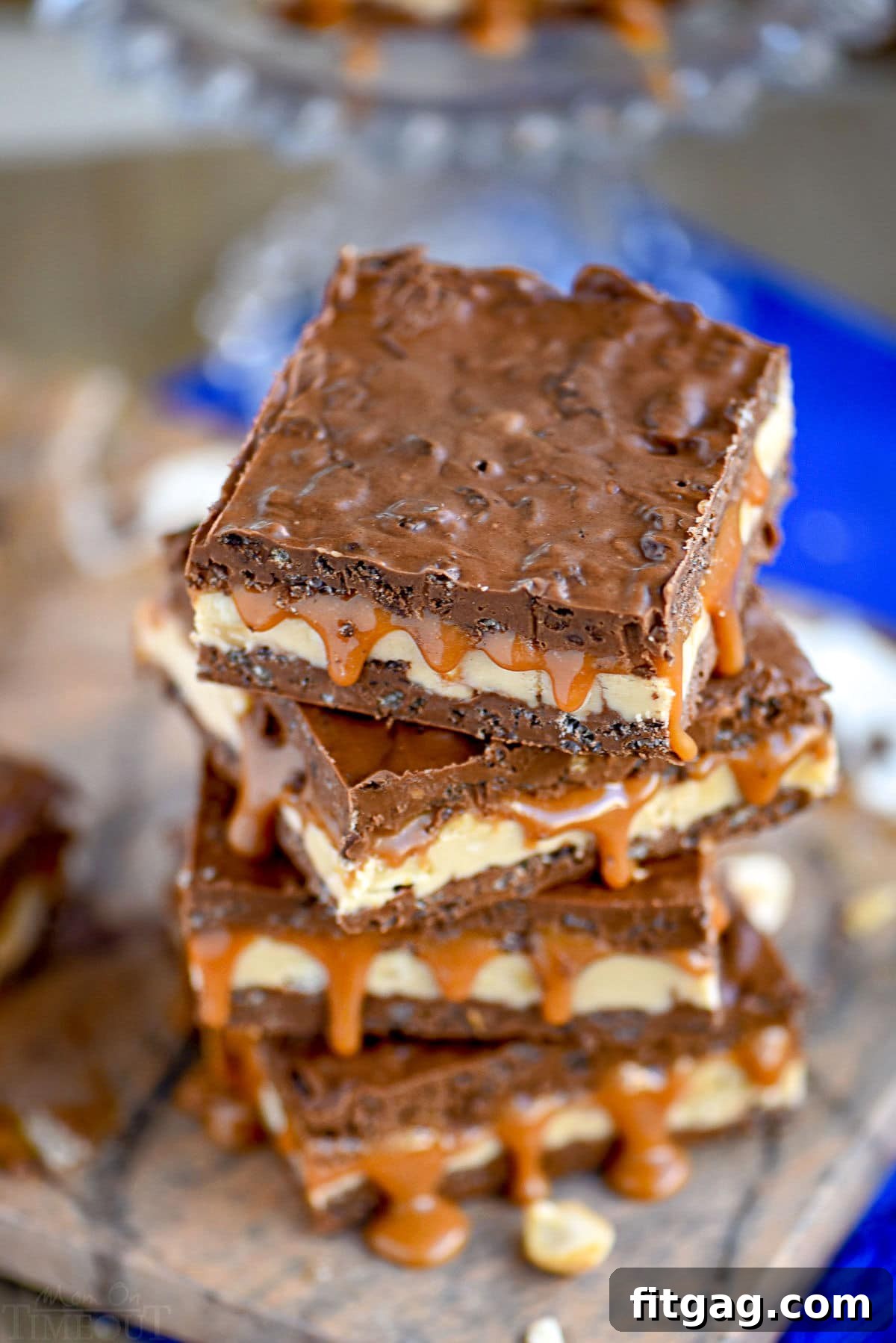top down look at a stack of crispy snickers bars with caramel dripping out of the sides.