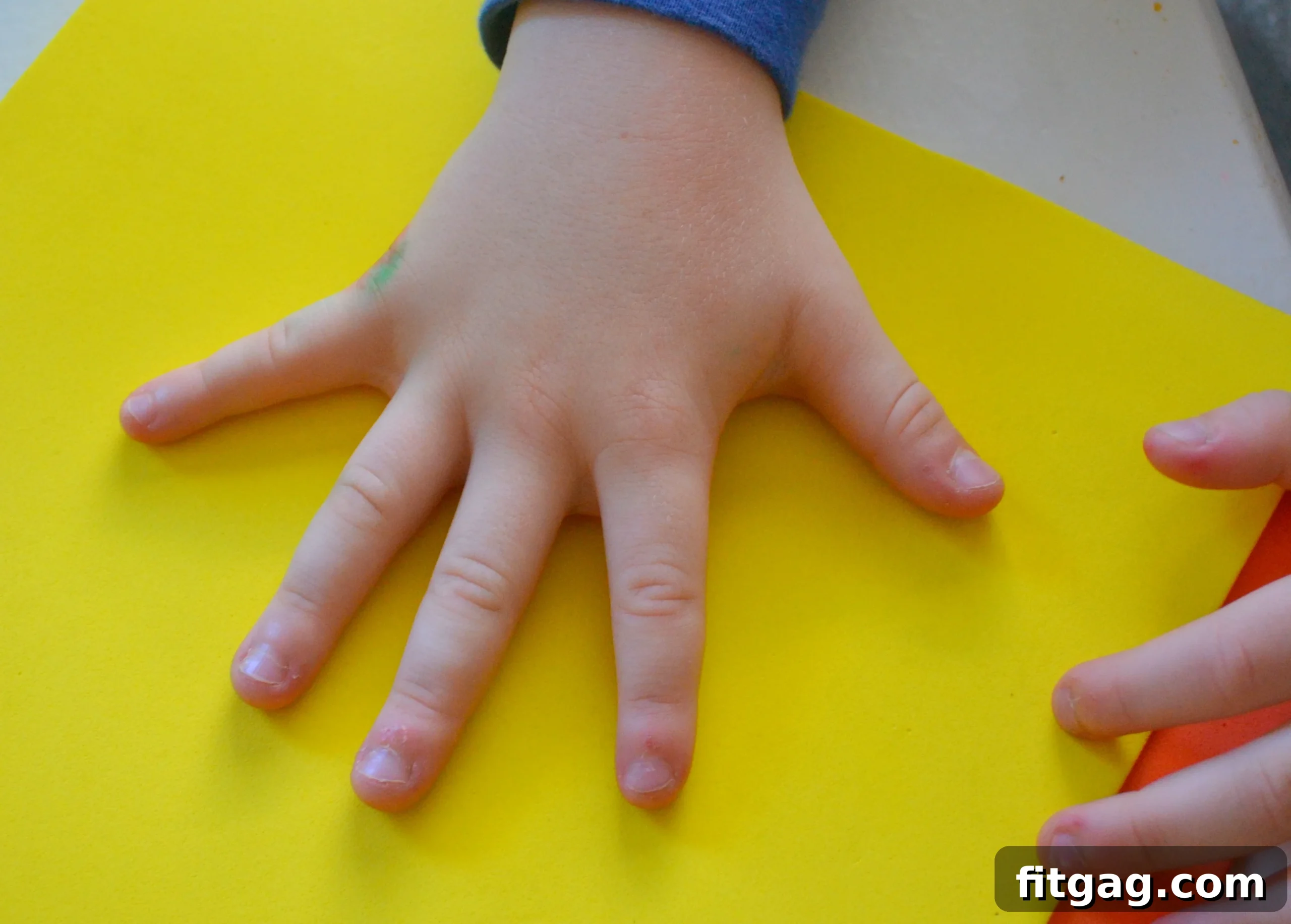 Tracing a child's hand on craft foam for turkey feathers