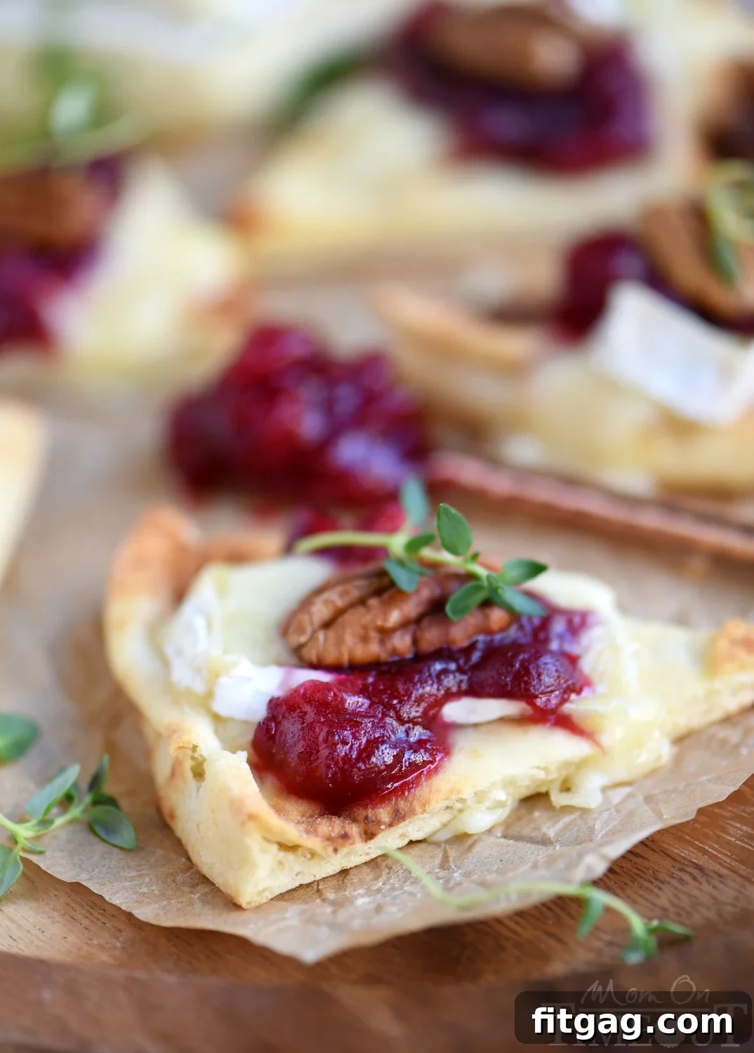 Beautifully plated Cranberry Pecan Brie Bites with fresh thyme garnish, ready for holiday serving